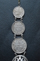 A 1915 COMMEMORATIVE CROSS & BONES WATCH FOB.