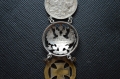 A 1915 COMMEMORATIVE CROSS & BONES WATCH FOB.