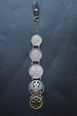 A 1915 COMMEMORATIVE CROSS & BONES WATCH FOB.